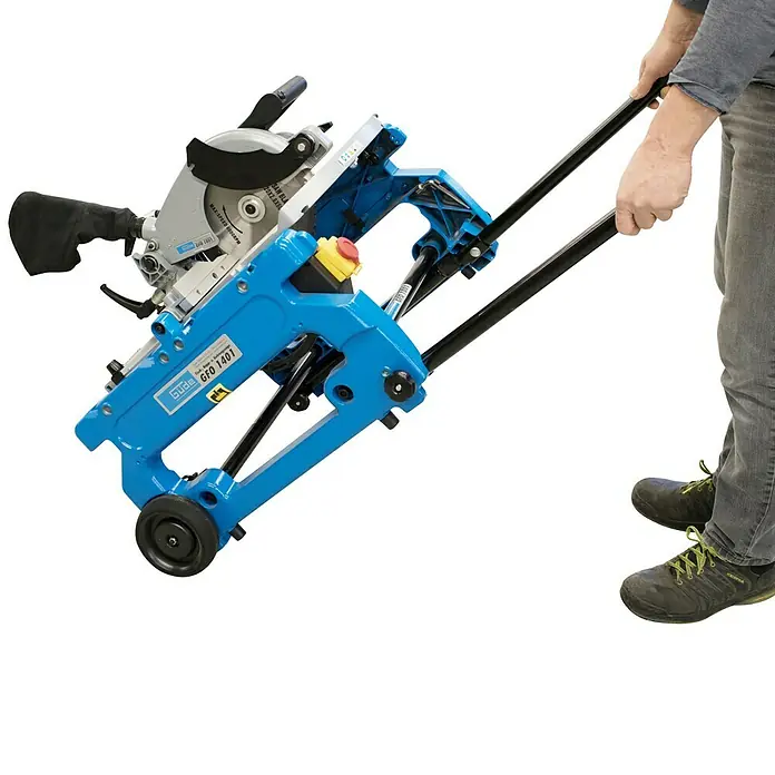 Güde Kapp- & Gehrungssäge GFO 1401 - 1.400 W, Durchmesser Sägeblatt: 216 mm, 5.000 U/min - Kreissäge auf einem blauen Wagen mit schwarzen Griffen und Rädern, die von einer Person gehalten und gezogen wird.