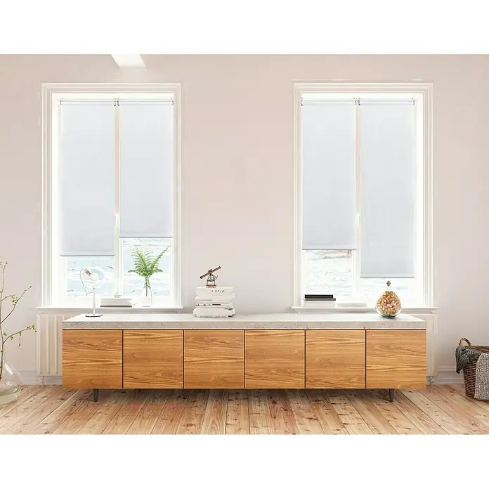 Estor enrollable Clip&Fix - An x Al: 45 x 180 cm, Blanco nieve - Estores enrollables blancas cubren las ventanas de una habitación luminosa, ofreciendo privacidad y dejando pasar la luz del día.