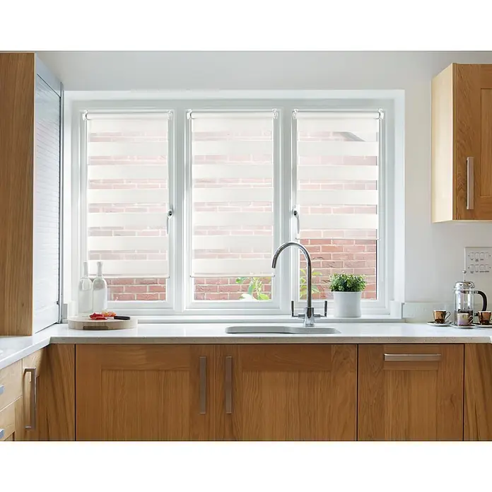 Estor noche y día Clip&Fix - An x Al: 45 x 180 cm, Blanco - Modernos estores enrollables dobles en una ventana de cocina con armarios de madera y un fregadero, que brindan privacidad y estilo.