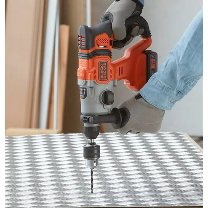 Black+Decker Martillo combinado de batería BCD900E2K - 18 V, 2 baterías, 1,2 J - Taladro percutor Black+Decker, sujetado por una mano con guante de trabajo, perforando un patrón de cuadros.
