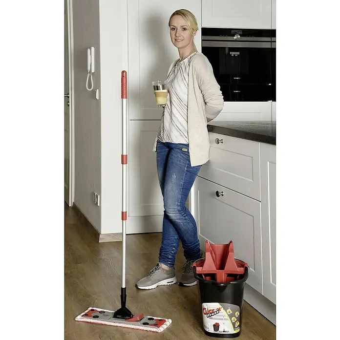 Sprintus Bodenwisch-Set Click N Press + Staubmop - 12 l, 5 -tlg., Materialzusammensetzung Bezug: 80 % Mikrofaser, 20 % weiche Abrasivborsten - Frau mit Click 'N' Press Wischmop-Set. Das Set beinhaltet einen Mopp und einen Eimer mit Auswringer, ideal für die schnelle und gründliche Reinigung.