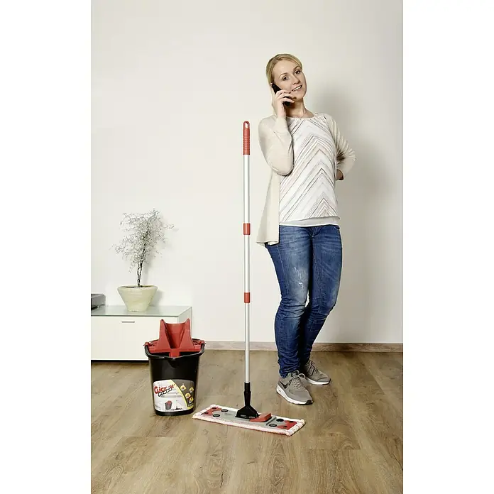 Sprintus Bodenwisch-Set Click N Press + Staubmop - 12 l, 5 -tlg., Materialzusammensetzung Bezug: 80 % Mikrofaser, 20 % weiche Abrasivborsten - Frau telefoniert beim Putzen mit dem Click 'N' Press Bodenwischsystem mit Eimer, ideal für die schnelle und gründliche Reinigung.