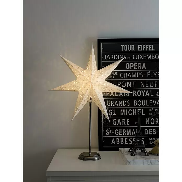 Konstsmide LED-Stern - Weiß, IP20, Netzbetrieben - Beleuchtete weiße Sternlampe auf einem Metallständer, auf einem weißen Tisch platziert.