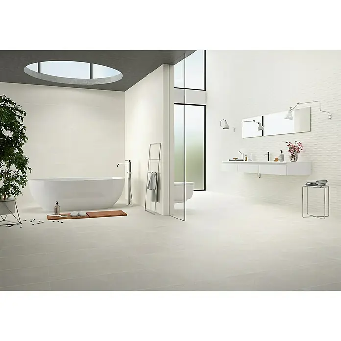 BHS Showroom Pavimento porcelánico Newlyn - 60 x 60 cm, Gris, Rectificado - Diseño de baño luminoso con bañera exenta, tocador con espejo e iluminación moderna para un ambiente elegante y confortable.