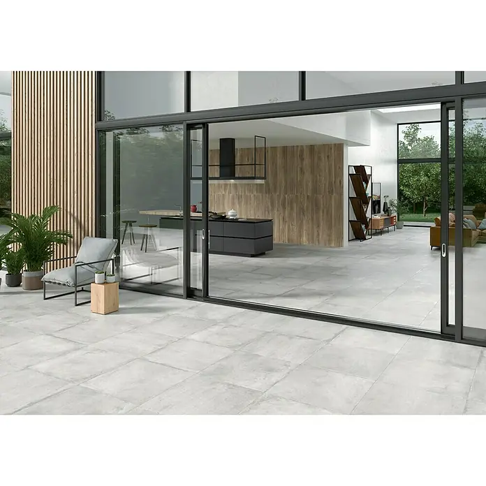 BHS Showroom Pavimento porcelánico Stoneage Soft - 60 x 60 cm, Concreto, Rectificado - Habitación espaciosa con diseño moderno y grandes baldosas que crean un ambiente abierto, complementado con una decoración elegante.