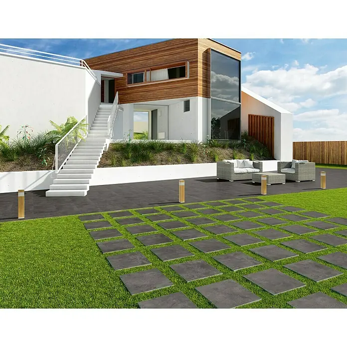 BHS Showroom Pavimento porcelánico Rodano - 60 x 60 cm, Antracita, Rectificado - Imagen exterior con baldosas de patio gris oscuro en un césped verde, creando un camino de jardín moderno y elegante.