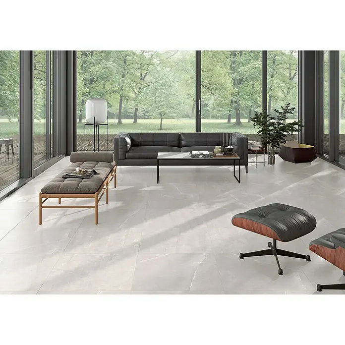 BHS Showroom Pavimento porcelánico Talo - 75 x 75 cm, Blanco, Rectificado - Elegante sala de estar con baldosas de gran formato en gris claro que crean un ambiente moderno y lujoso. Las baldosas aportan amplitud y luminosidad al espacio.