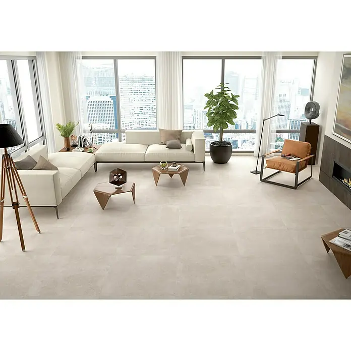 BHS Showroom Pavimento porcelánico Claire - 60 x 60 cm, Arena, Rectificado - Salón luminoso con grandes baldosas. Zona de estar moderna con mucha luz natural, sofás blancos y diseño minimalista para un ambiente elegante.