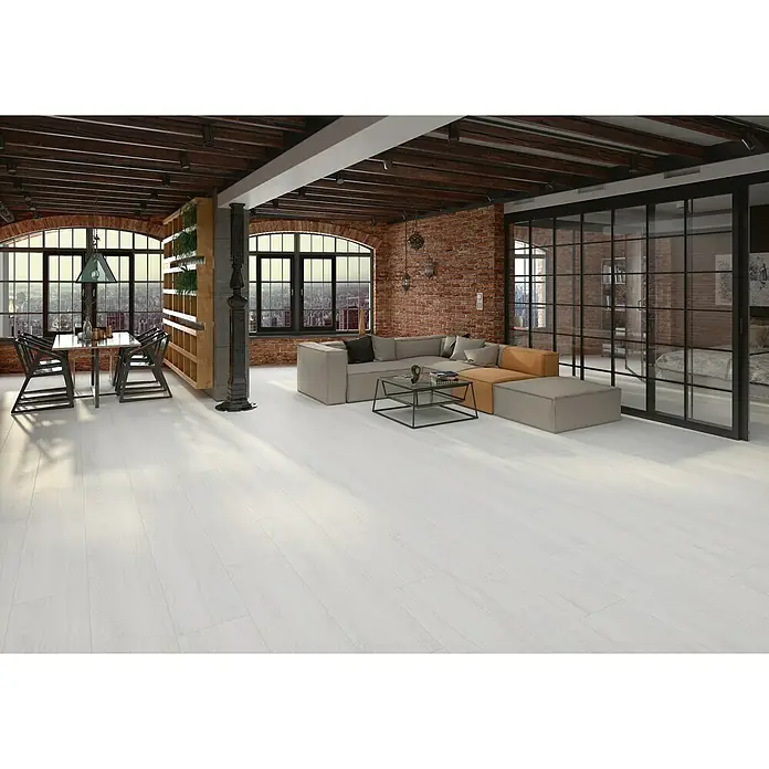 BHS Showroom Pavimento porcelánico Ninsba - 90 x 15 cm, Blanco, Rectificado - Interior de una sala de estar con pisos de madera blanca, sofá modular, mesa y sillas en un ambiente moderno tipo loft.