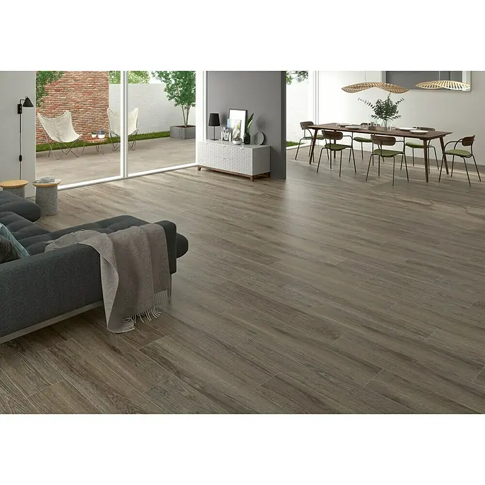 BHS Showroom Pavimento porcelánico Ninsba - 150 x 30 cm, Marrón, Rectificado - Elegante salón con suelo de gres imitación madera en tonos marrones cálidos, creando un ambiente natural y acogedor.