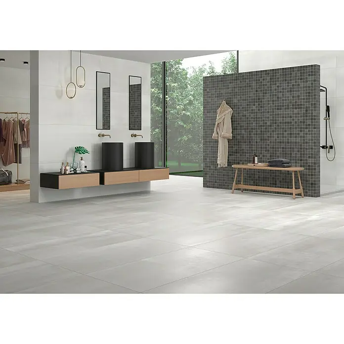 BHS Showroom Pavimento porcelánico Steel - 60 x 120 cm, Gris, Rectificado - Baño con azulejos grises, lavabos con mueble de madera, toallero y gran ventana para un ambiente moderno y luminoso.