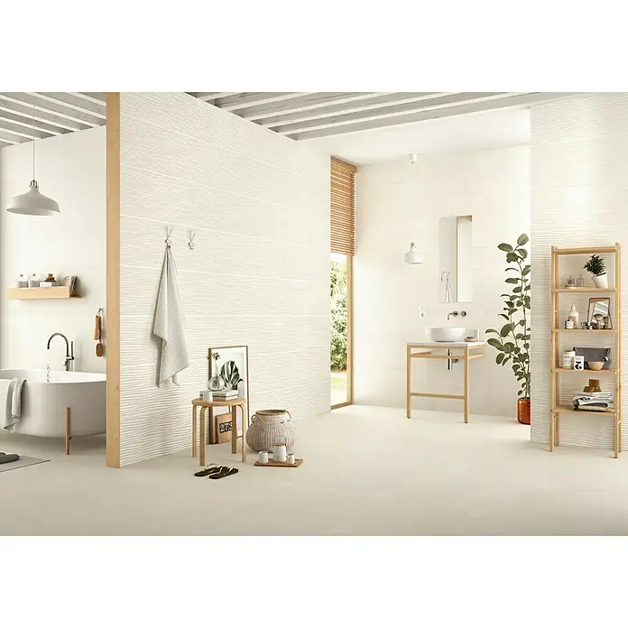 BHS Showroom Pavimento porcelánico Newlyn - 60 x 60 cm, Almond, Rectificado - Baño con azulejos blancos texturizados en las paredes, bañera, lavabo y estanterías de madera.