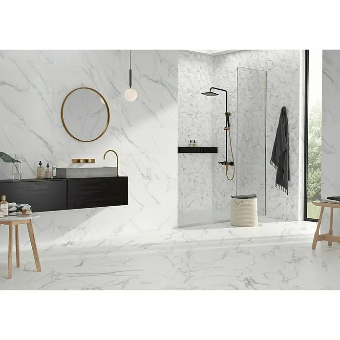 BHS Showroom Pavimento porcelánico Aston - 60 x 60 cm, Blanco, Rectificado - Un baño moderno con azulejos de mármol, un tocador oscuro y detalles dorados para una apariencia elegante y sofisticada.