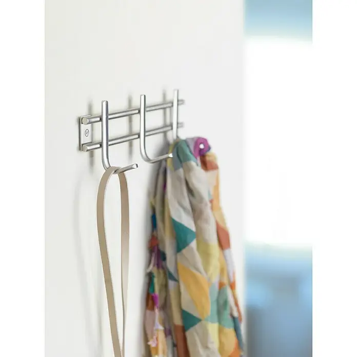 Inofix Perchero 3716 - L x An x Al: 220 x 76 x 54 mm, Acero inoxidable, Plateado - Un moderno perchero de metal en una pared blanca con un cinturón y una bufanda colorida. Práctico y elegante para cualquier habitación.
