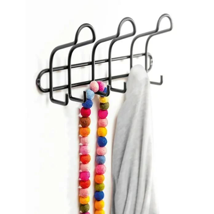 Inofix Perchero 3719 - L x An x Al: 310 x 84 x 130 mm, Acero, Negro - Perchero de pared de metal negro con pompones coloridos y una prenda gris colgada de los ganchos.