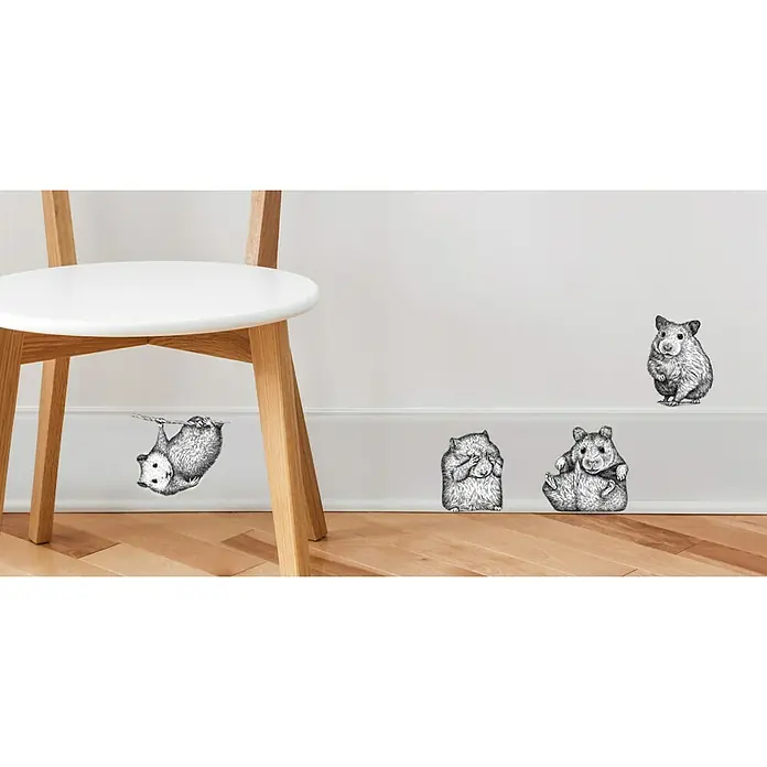 Vinilo de pared - Blanco/Negro, Plástico - Adhesivos de pared de hámster encantadores en varias posiciones que adornan una pared blanca junto a una silla, añadiendo un toque lúdico.