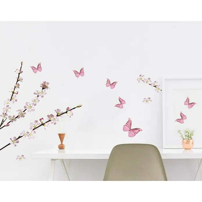 Adhesivos decorativos - Rama de manzano en flor, 0,5 x 21 cm, Multicolor - Primer plano de una habitación con una cómoda blanca, una silla, flores rosas y pegatinas de pared de mariposas para un ambiente sereno.