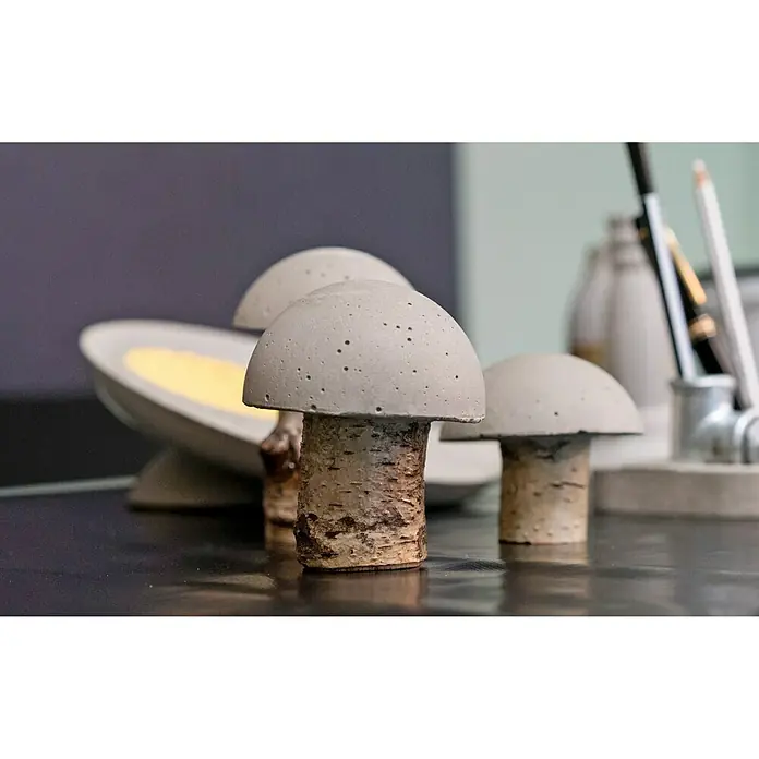 Ultrament Beton-Gießmasse Bastel Beton - Hellgrau, 1,5 kg - Nahaufnahme von drei handgefertigten Pilzfiguren aus Beton und Holz, die auf einer glänzenden Oberfläche stehen.