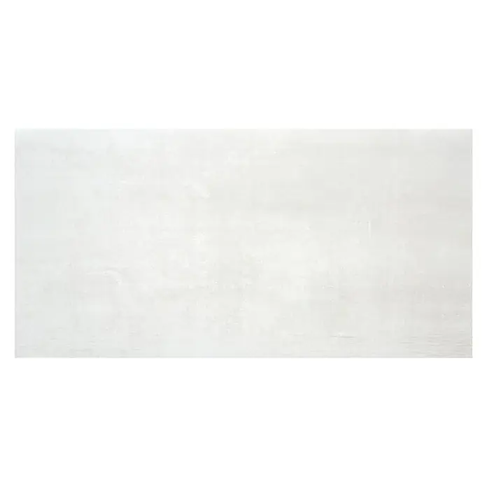 BHS Showroom Pavimento porcelánico Steel - 60 x 120 cm, Blanco, Rectificado - Pared de hormigón gris con manchas ligeramente texturizadas, creando un fondo moderno e industrial.