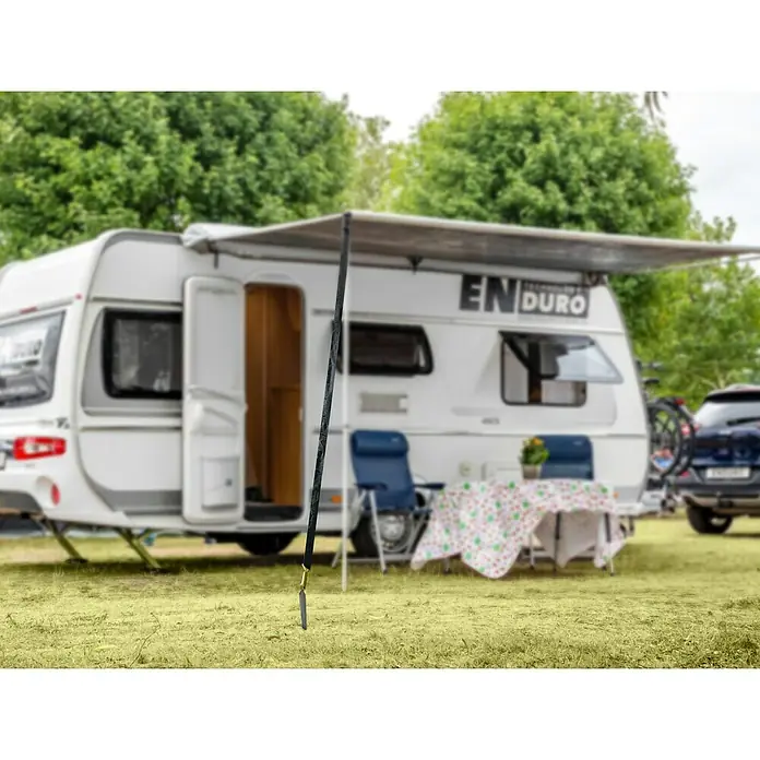 Abspann-Set - Zelte, 6 -tlg. - Ein Campingplatz mit einem weißen Wohnwagen und einer Markise, die mit einem schwarzen Seil befestigt ist, um Schatten zu spenden.
