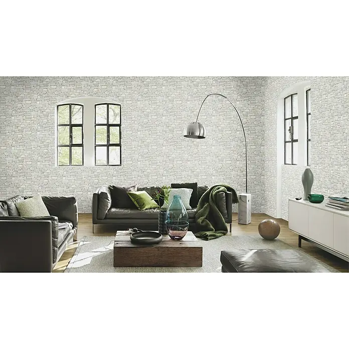 Rasch Vliestapete - Graubeige, Steinoptik, 10,05 x 0,53 m - Ein elegantes Wohnzimmer mit einer stilvollen Steinmauer-Tapete, die dem Raum einen Hauch von rustikalem Charme verleiht. Die Tapete ist ein echter Hingucker.