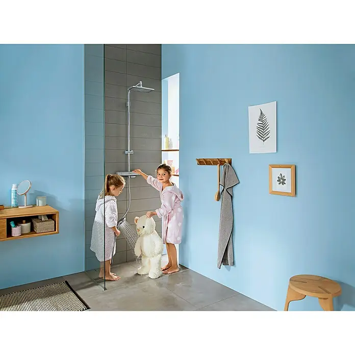 Hansgrohe Croma E Duschsystem Showerpipe 280 1jet Varia - Mit Thermostatarmatur, Lochabstand: 80 cm - 90 cm, Anzahl Strahlarten: 4 Stk., Chrom - Badezimmerszene mit zwei Mädchen, die einem Teddybären mit einer Duschgarnitur von Hansgrohe ein Bad geben.