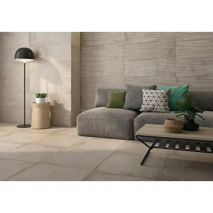 Pavimento porcelánico Origin - 60 x 60 cm, Arena, Rectificado - Salón con baldosas beige y revestimientos de imitación madera, acentuado por una lámpara de pie moderna y muebles elegantes.