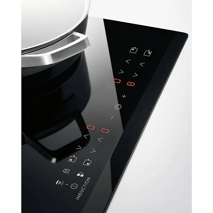 Electrolux Placa de cocción LIT60336C - Número de fogones de inducción: 3 ud. - Primer plano de una placa de inducción con una elegante superficie de vidrio negro y controles táctiles.
