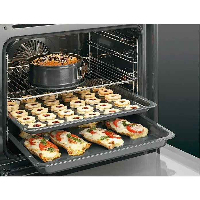 AEG Horno empotrado BPE53512YM - Número de tipos de calentamiento: 10 ud., Volumen horno: 71 l - Un horno abierto que muestra un pastel, galletas y bruschetta en diferentes rejillas. La comida tiene un aspecto apetitoso y recién horneado.