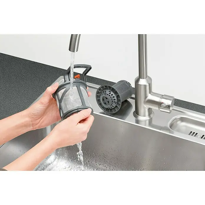 AEG Lavavajillas integrable FSE62417P - Ancho: 45 cm, Número de cubiertos: 9 ud. - Un filtro de lavavajillas limpiándose bajo un grifo para mantener su funcionalidad.