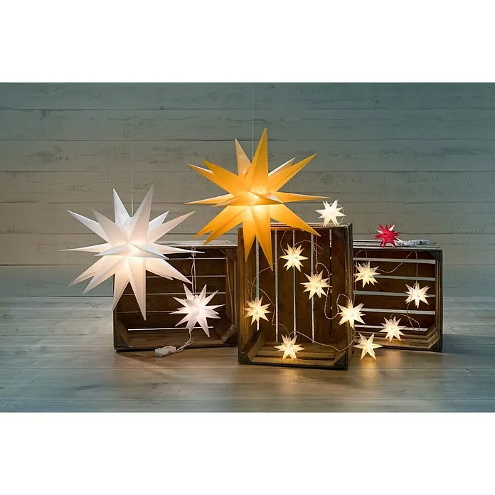 Tween Light LED-Stern 3D Kunststoff hängend - 50 cm, Weiß, Lichtfarbe: Warmweiß, IP44, Netzbetrieben - Eine festliche Anordnung von beleuchteten Papiersternen in Weiß, Gelb und Rot, die eine gemütliche und warme Urlaubsstimmung erzeugen.