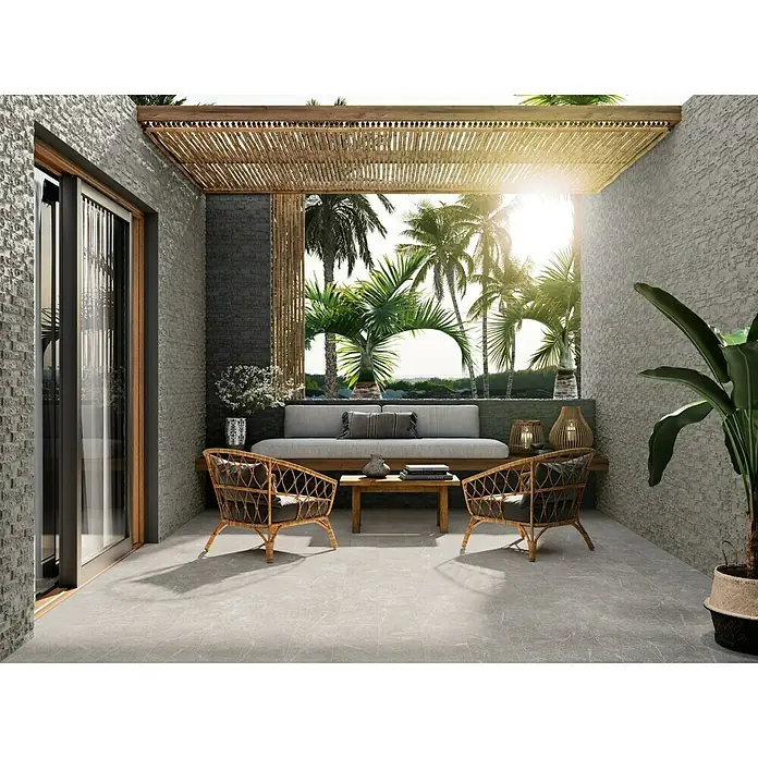 Verblendstein Irazu Antracita - 60 x 20 cm, Anthrazit, Steinoptik - Ein stilvoller Außenbereich mit grauem Fliesenboden, Rattanmöbeln und einem schattenspendenden Bambusdach, der zum Verweilen einlädt.