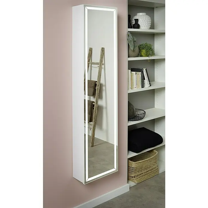 Riva Spiegel-Hochschrank Alex - 36 x 16,5 x 155 cm, Mit Beleuchtung, Weiß - Das Bild zeigt einen weißen, beleuchteten Spiegelschrank an einer Wand, der einen dekorativen Raum mit Regalen und Accessoires reflektiert.