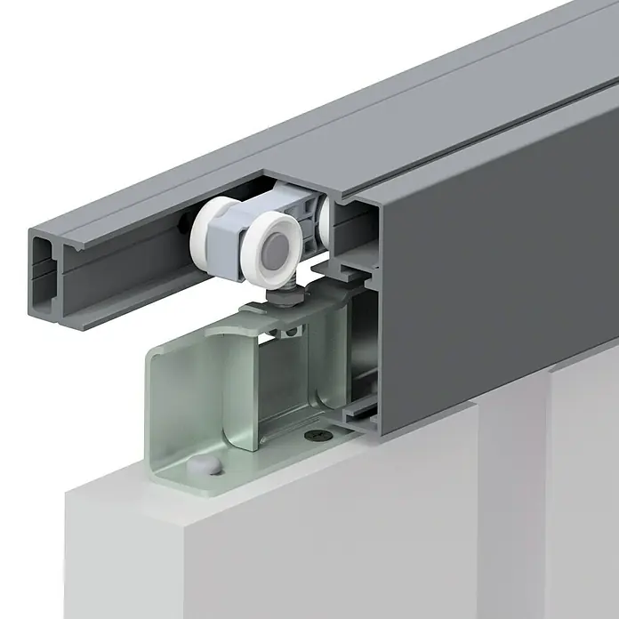 Kilsgaard Schiebetür-Komplettset 422-L - 935 x 2.050 mm, Weiß, Wabe - Detailaufnahme einer grauen Schiebetürschiene mit Rollenaufhängung und silberfarbener Halterung, die auf einer weißen Oberfläche montiert ist.