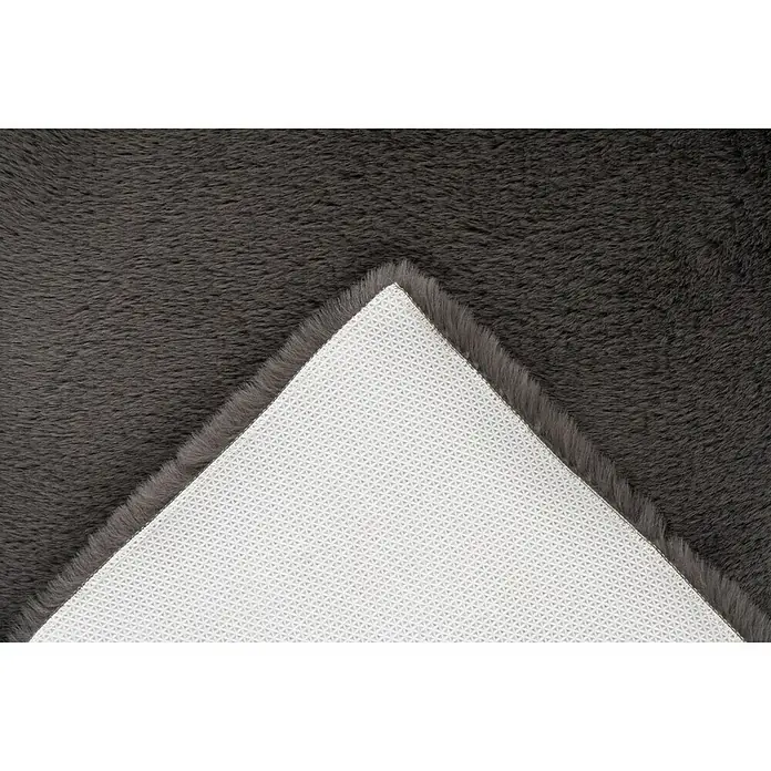 Badteppich Happy - 50 x 90 cm, Grau, 100% Polyester - Nahaufnahme eines grauen Shaggy-Teppichs, der die weiche Textur und die rutschfeste Unterseite zeigt. Ein luxuriöses und bequemes Wohnaccessoire.