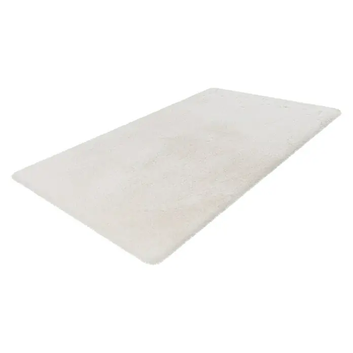 Badteppich Happy - 67 x 110 cm, Weiß, 100% Polyester - Ein rechteckiger, cremefarbener Teppich mit hohem Flor liegt auf einem weißen Hintergrund. Der Teppich hat eine weiche, flauschige Textur.