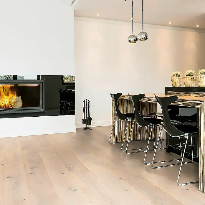 Fertigparkett - Eiche Natura, 1.900 x 190 x 14 mm, Landhausdiele - Moderne Esszimmer-Szene mit einem markanten Esstisch, eleganten Stühlen und einem Kamin, der eine warme Atmosphäre schafft.