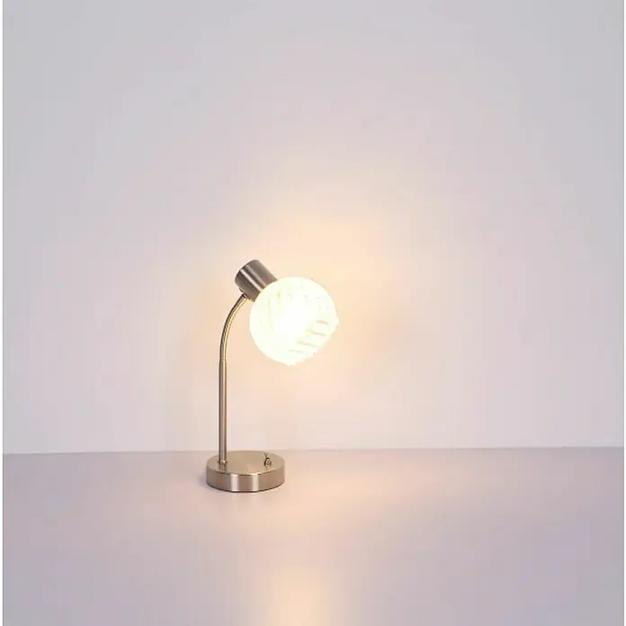 Globo Tischleuchte Willy - 40 W, L x B x H: 24 x 23 x 40 cm, Nickel Matt, E27 - Nahaufnahme einer modernen Tischleuchte mit Metallfuß und einem runden, leuchtenden Lampenschirm, die warmes Licht auf eine ebene Fläche wirft.