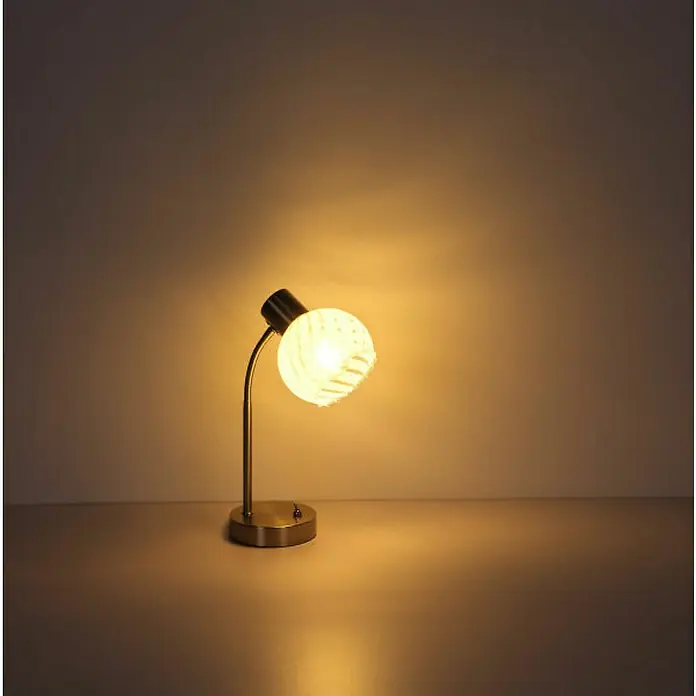 Globo Tischleuchte Willy - 40 W, L x B x H: 24 x 23 x 40 cm, Nickel Matt, E27 - Diese Nahaufnahme zeigt eine elegante, goldene Tischleuchte mit einem runden, gemusterten Lampenschirm, die ein warmes Licht ausstrahlt.