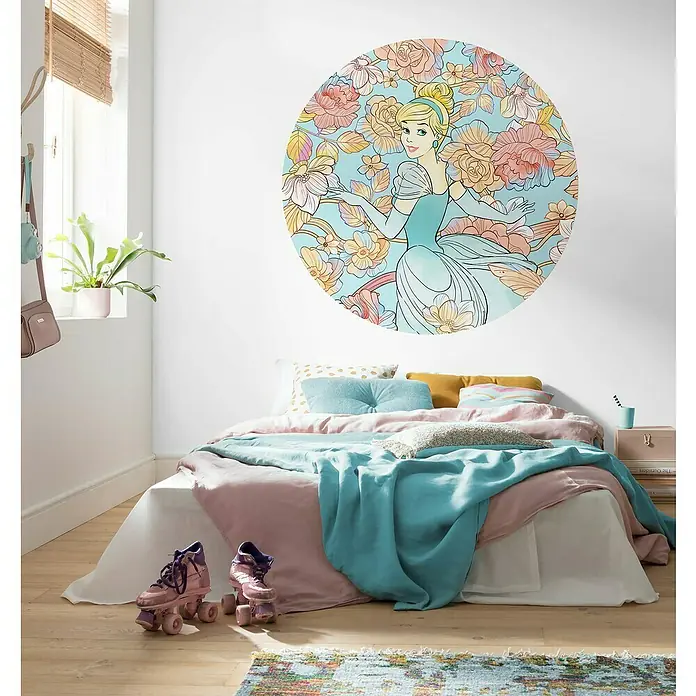 Komar Dots Fototapete rund Cinderella Pastel Dreams - 125 cm, Selbstklebend - Ein Kinderzimmer mit einem großen Cinderella-Wandsticker mit Blumenmuster über einem mit rosa und türkisfarbener Bettwäsche dekorierten Bett.