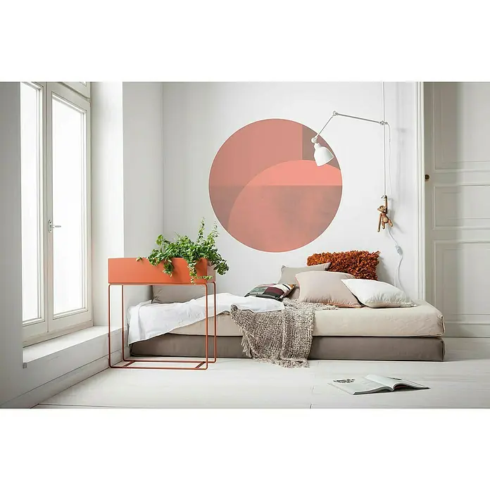 Komar Dots Fototapete rund Roselux - 125 cm, Selbstklebend - Ein Zimmer mit einem stilvollen orangefarbenen Pflanzgefäß auf einem Metallgestell, das neben einem Fenster und einem Tagesbett steht.