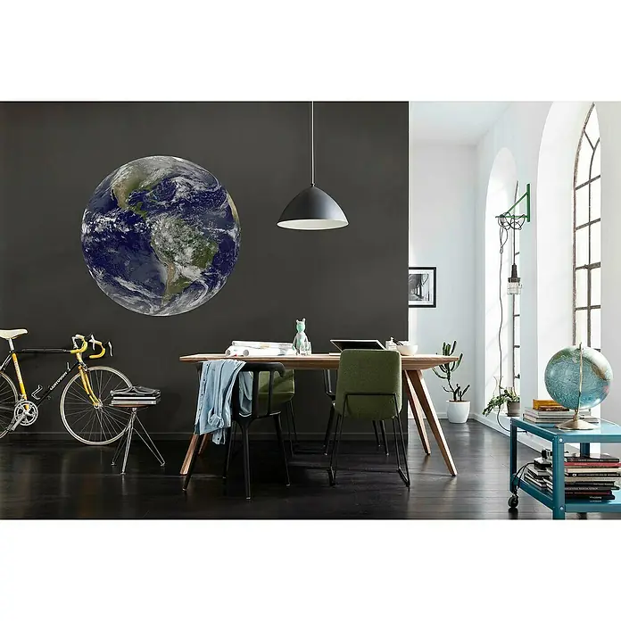 Komar Dots Fototapete rund Earth - 125 cm, Selbstklebend - Der Raum zeigt einen Globus an der Wand, eine Pendelleuchte und einen Tisch mit Stühlen, der ein modernes und erdiges Ambiente schafft.