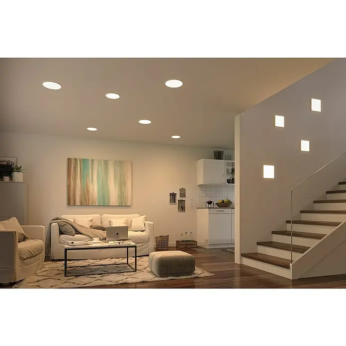 Paulmann LED-Panel Veluna VariFit - 17 W, L x B x H: 18,5 x 18,5 x 3,1 cm, Satin, Warmweiß - Innenaufnahme eines Wohnzimmers mit LED-Deckenspots und Wandleuchten, die für eine angenehme Beleuchtung sorgen.\n