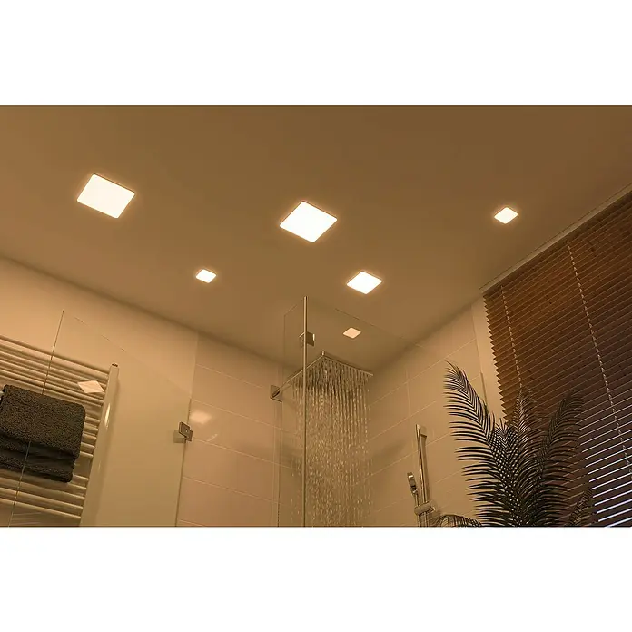 Paulmann LED-Panel Veluna VariFit - 4,5 W, L x B x H: 7,5 x 7,5 x 3,1 cm, Satin, Warmweiß, 3.000 K - Ein modern eingerichtetes Badezimmer mit Deckenleuchten, die für eine helle und einladende Atmosphäre sorgen, und einer Dusche mit Glasabtrennung.
