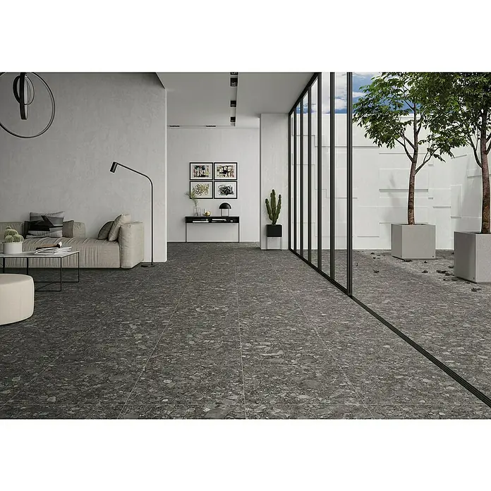 BHS Showroom Pavimento porcelánico Ceppo - 60 x 60 cm, Antracita, Rectificado - Interior elegante con piso de terrazo, un sofá claro y decoración minimalista, creando un ambiente de vida moderno y elegante.