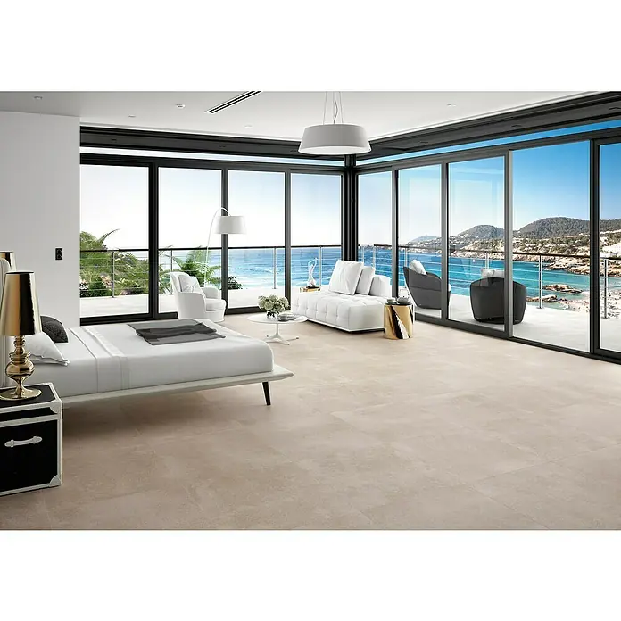 Pavimento porcelánico Claire - 60 x 60 cm, Taupe, Rectificado - Elegante dormitorio con suelo de baldosas beige y vista al mar. El suelo de baldosas le da al espacio un toque moderno y lujoso.