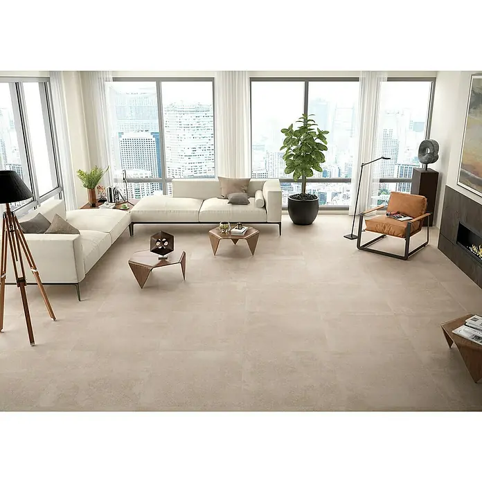 BHS Showroom Pavimento porcelánico Claire - 100 x 100 cm, Taupe, Rectificado - Elegante sala de estar con baldosas beige, sofás blancos y grandes ventanales con vistas a la ciudad.