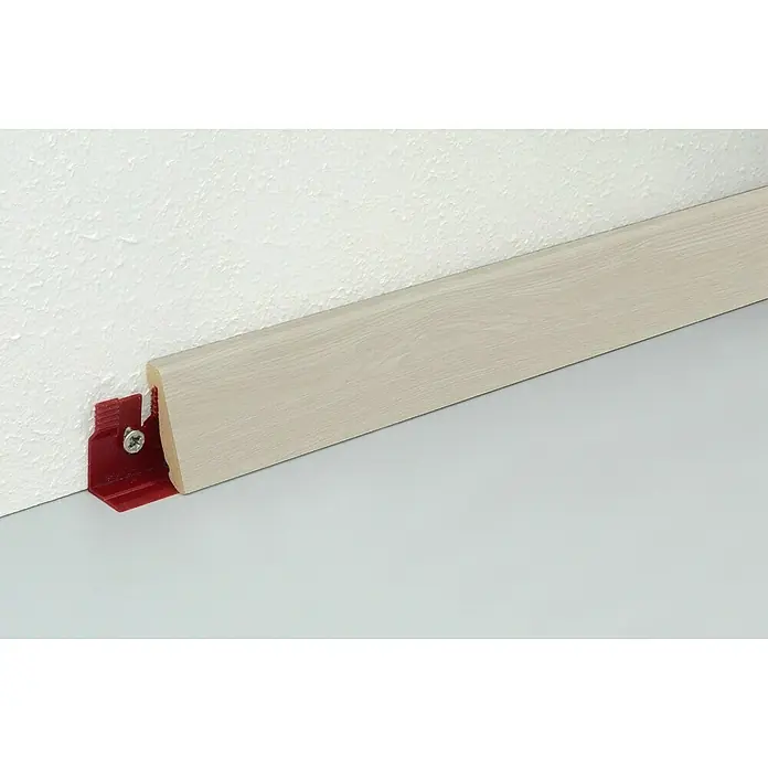 Profiles and more Sockelleiste FU147H Eiche Weiß - 240 cm x 18,5 mm x 38,5 mm, MDF - Sockelleiste in hellem Holzdesign mit roter Befestigungsklammer an weißer Wand und grauem Boden.