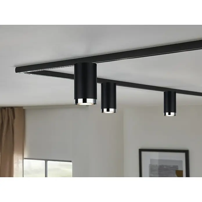 Paulmann URail LED-Spot Tube - Schwarz, Chrom, GU10, Ø x H: 6,5 x 11,2 cm - Nahaufnahme von drei modernen schwarzen Deckenstrahlern an einer schwarzen Schiene, die ein elegantes Beleuchtungssystem zeigen.