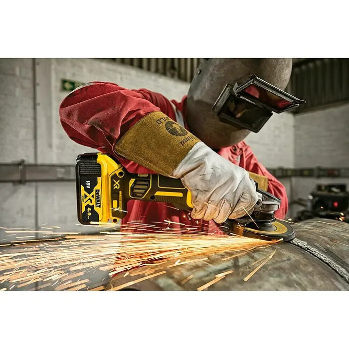 DeWalt XR 18V Amoladora angular de batería DCG405NT - 18 V, Sin batería, Diámetro disco: 125 mm, Número de revoluciones de marcha en vacío: 9.000 r.p.m. - Amoladora angular inalámbrica DeWalt en acción, con chispas volando al pulir una tubería de metal.